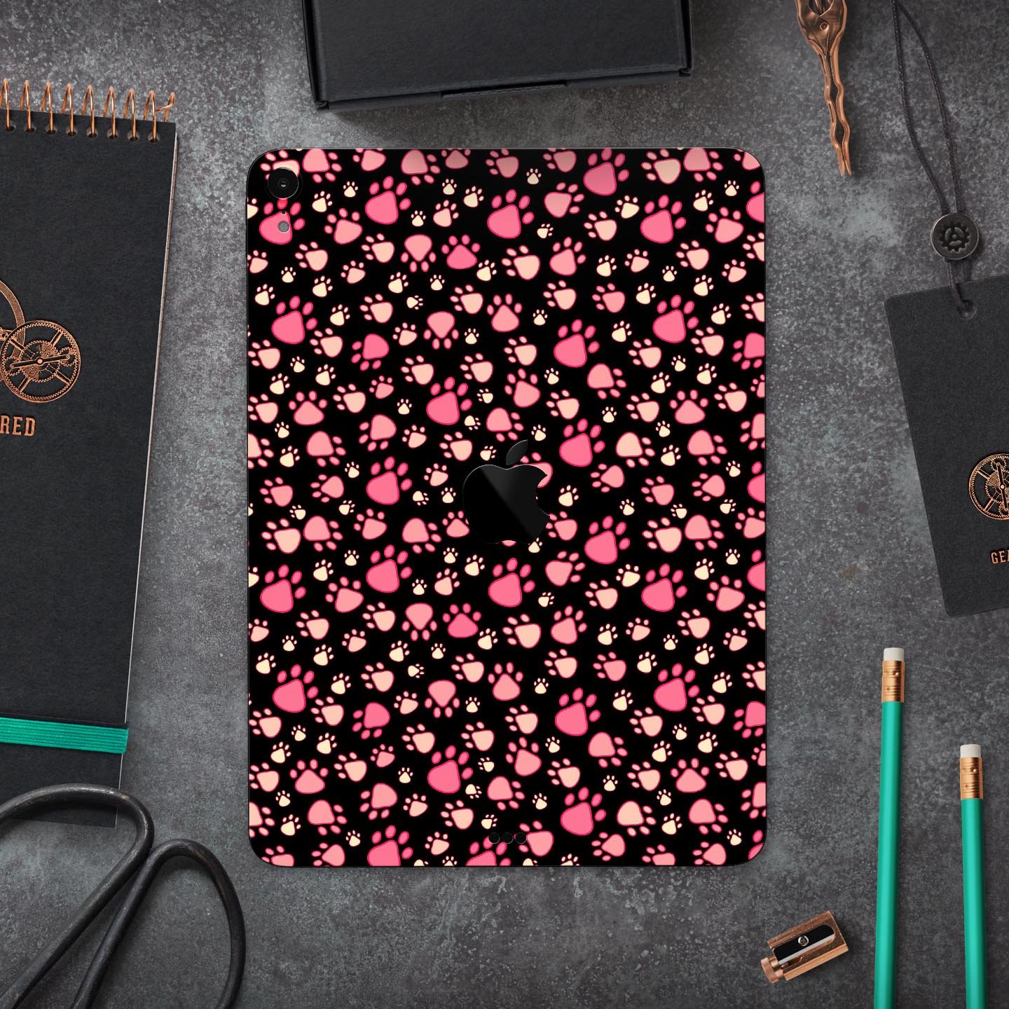 Full body skin decal featuring pink paw prints on a black background designed for Apple iPad Pro, showcasing its stylish and protective features.