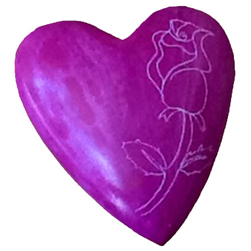 A beautifully hand-carved pink soapstone heart featuring an etched rose design, showcasing the craftsmanship of Haitian artisans.