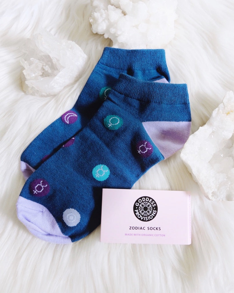 A pair of stylish socks featuring colorful planetary symbols on a soft organic cotton fabric.