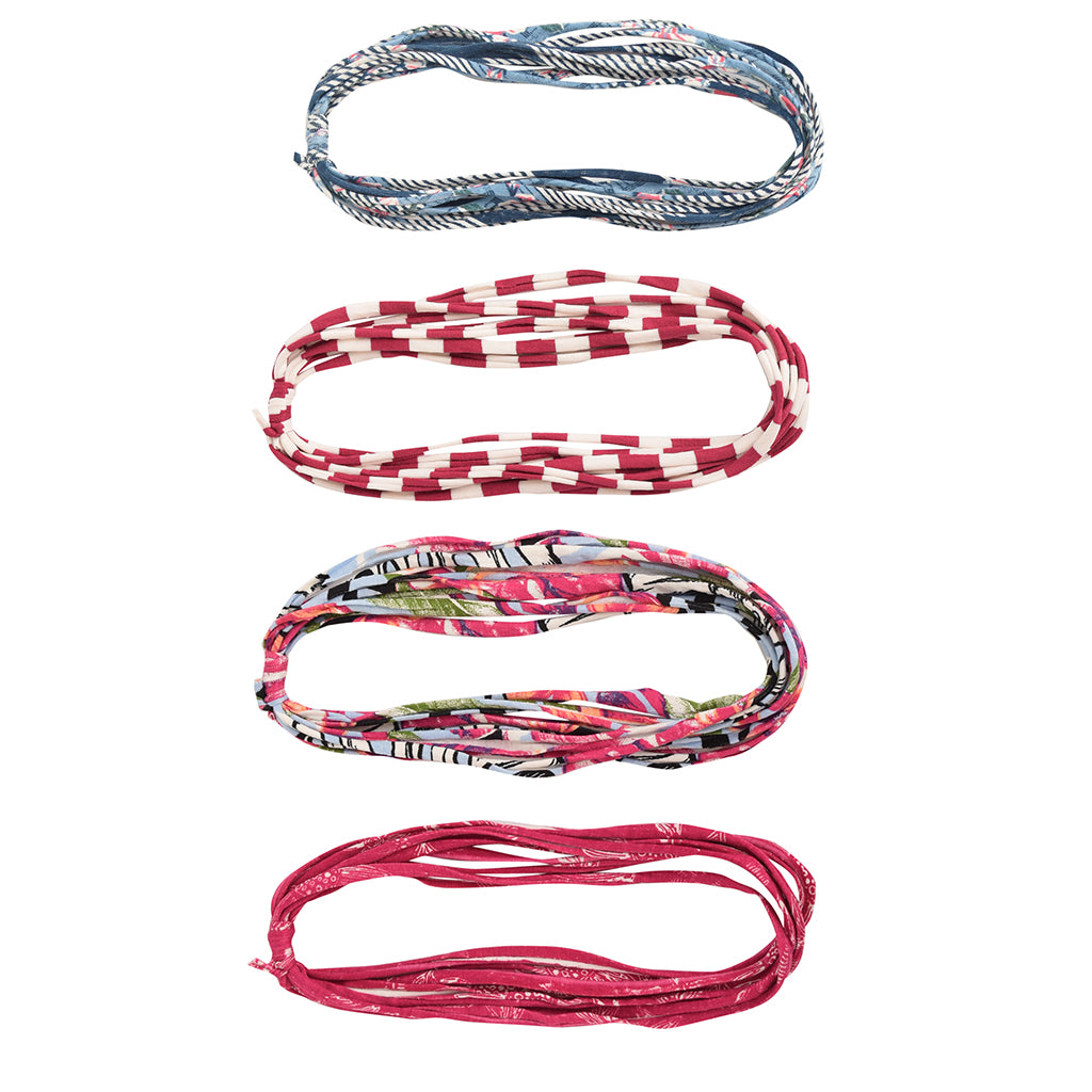 A colorful assortment of Prints + Patterns Bela Bands, showcasing their versatility as headbands and bracelets.