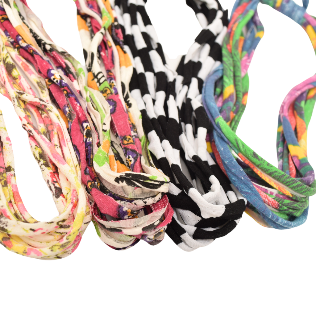 A colorful assortment of Prints + Patterns Bela Bands, showcasing their versatility as headbands and bracelets.