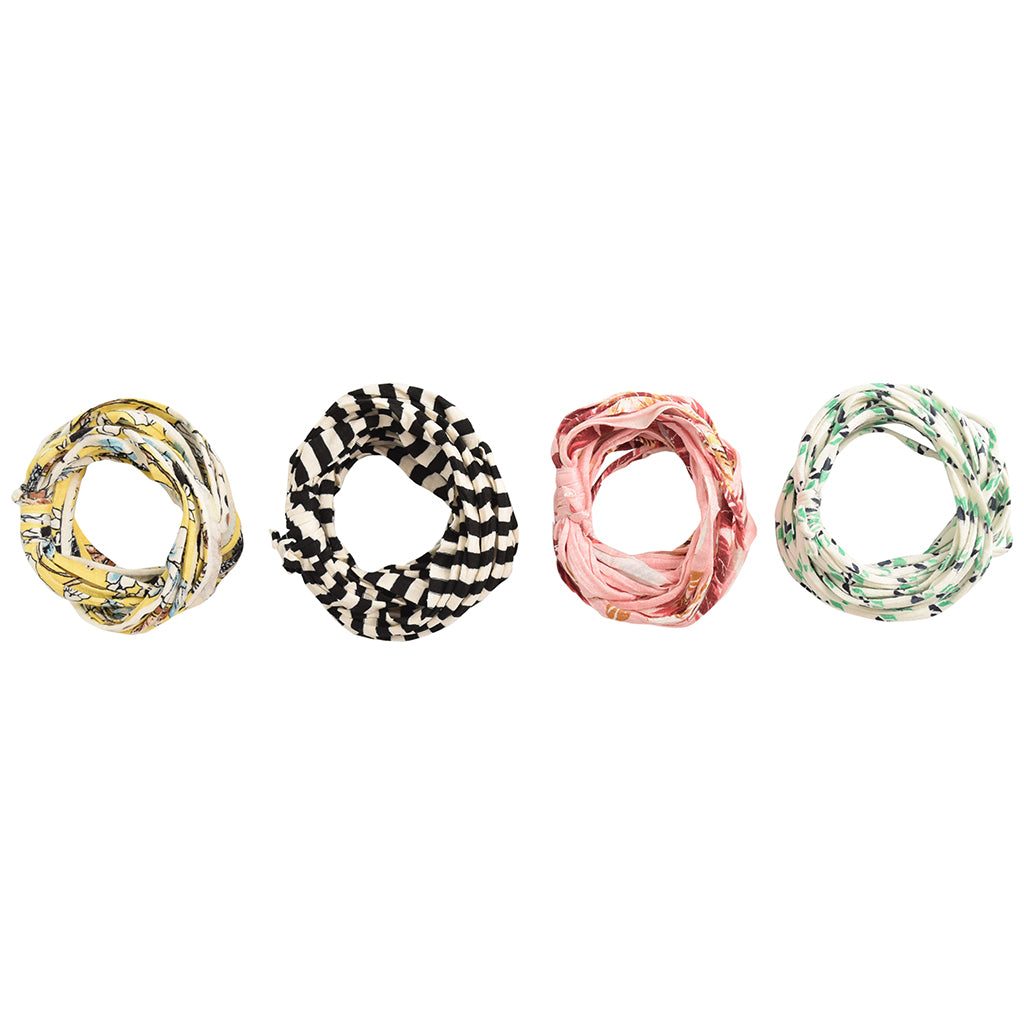 A colorful assortment of Prints + Patterns Bela Bands, showcasing their versatility as headbands and bracelets.