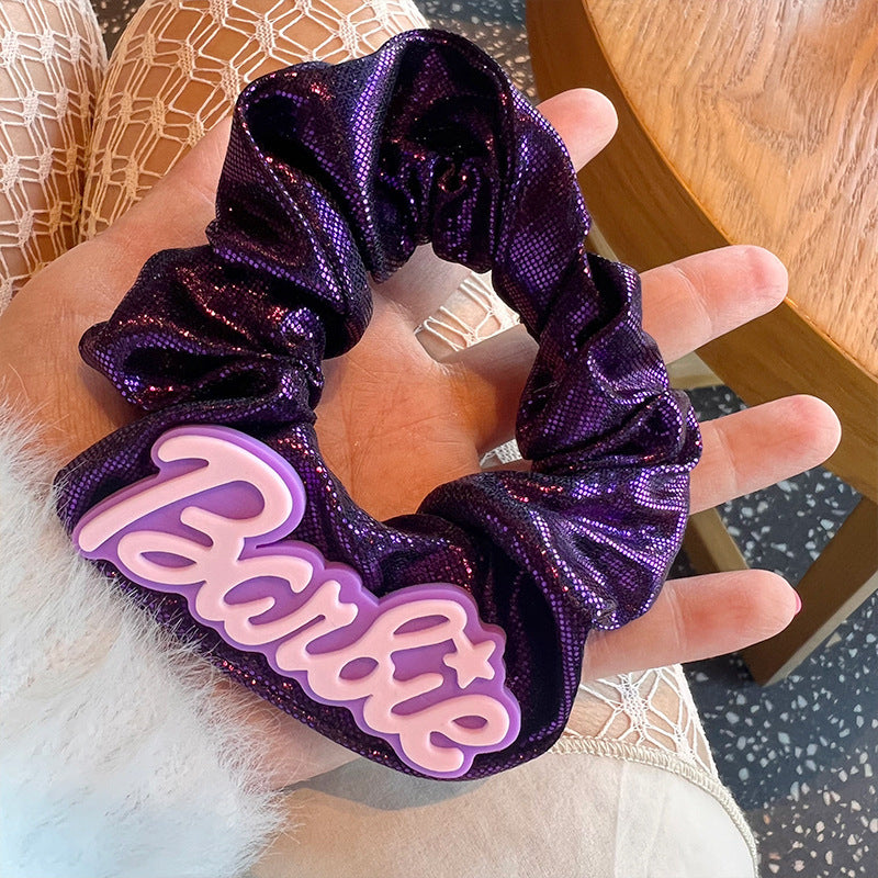 Purple shiny hair tie with Barbie stickers, stylish accessory for women.