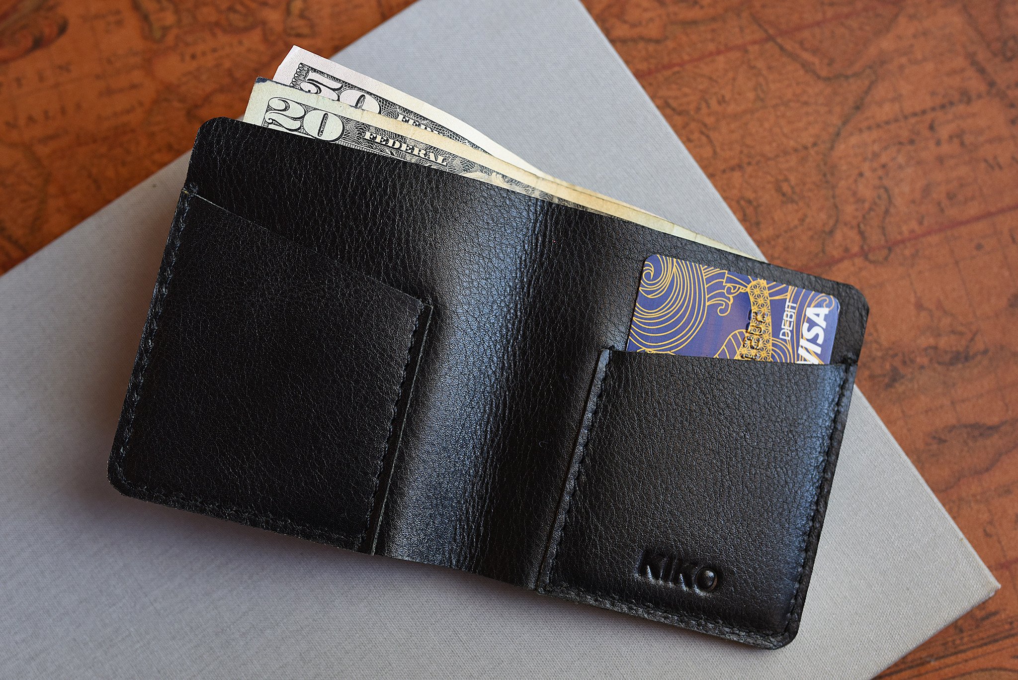 A sleek black leather Ram Wallet with two card slots and a bill compartment, showcasing its minimalistic design.