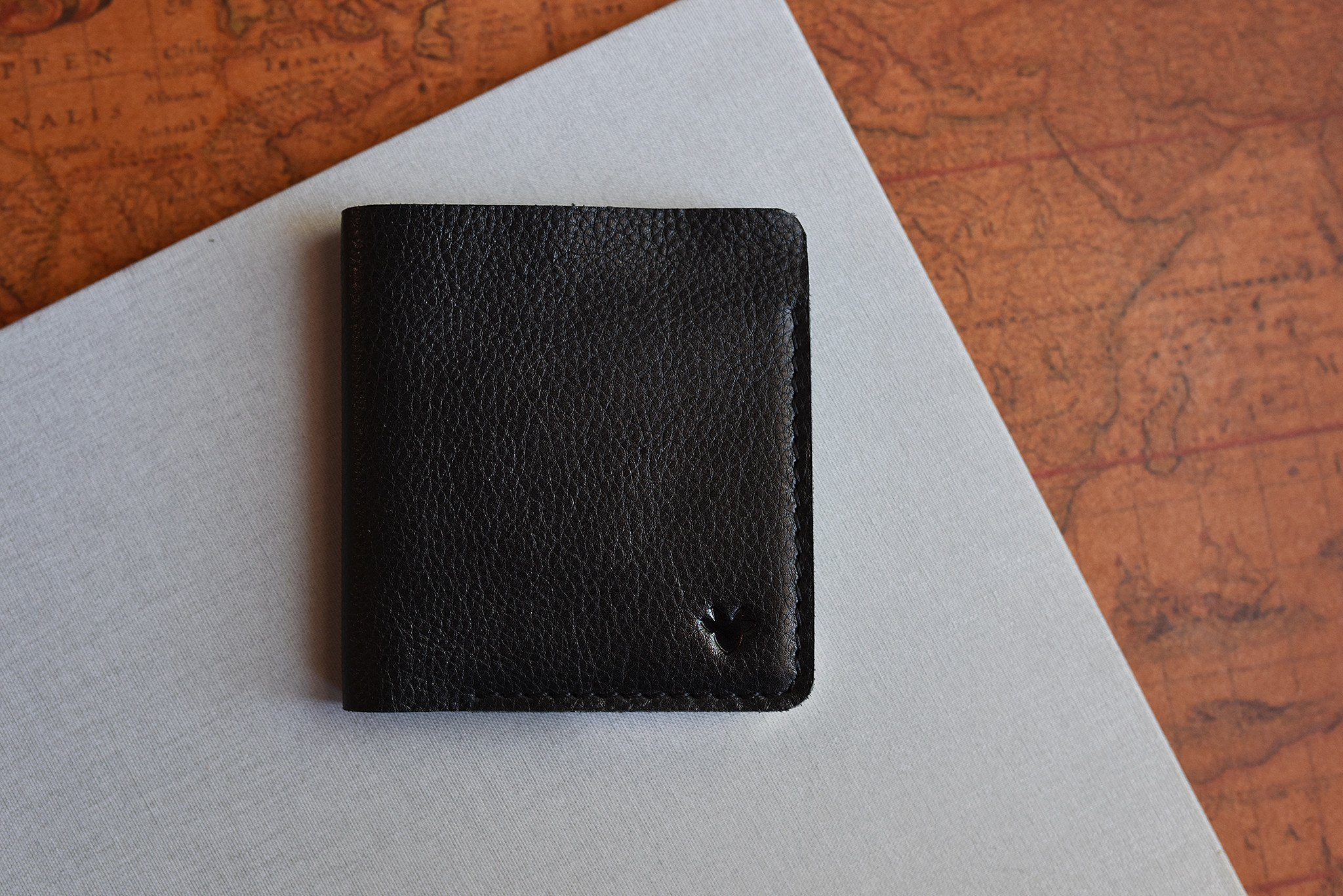 A sleek black leather Ram Wallet with two card slots and a bill compartment, showcasing its minimalistic design.