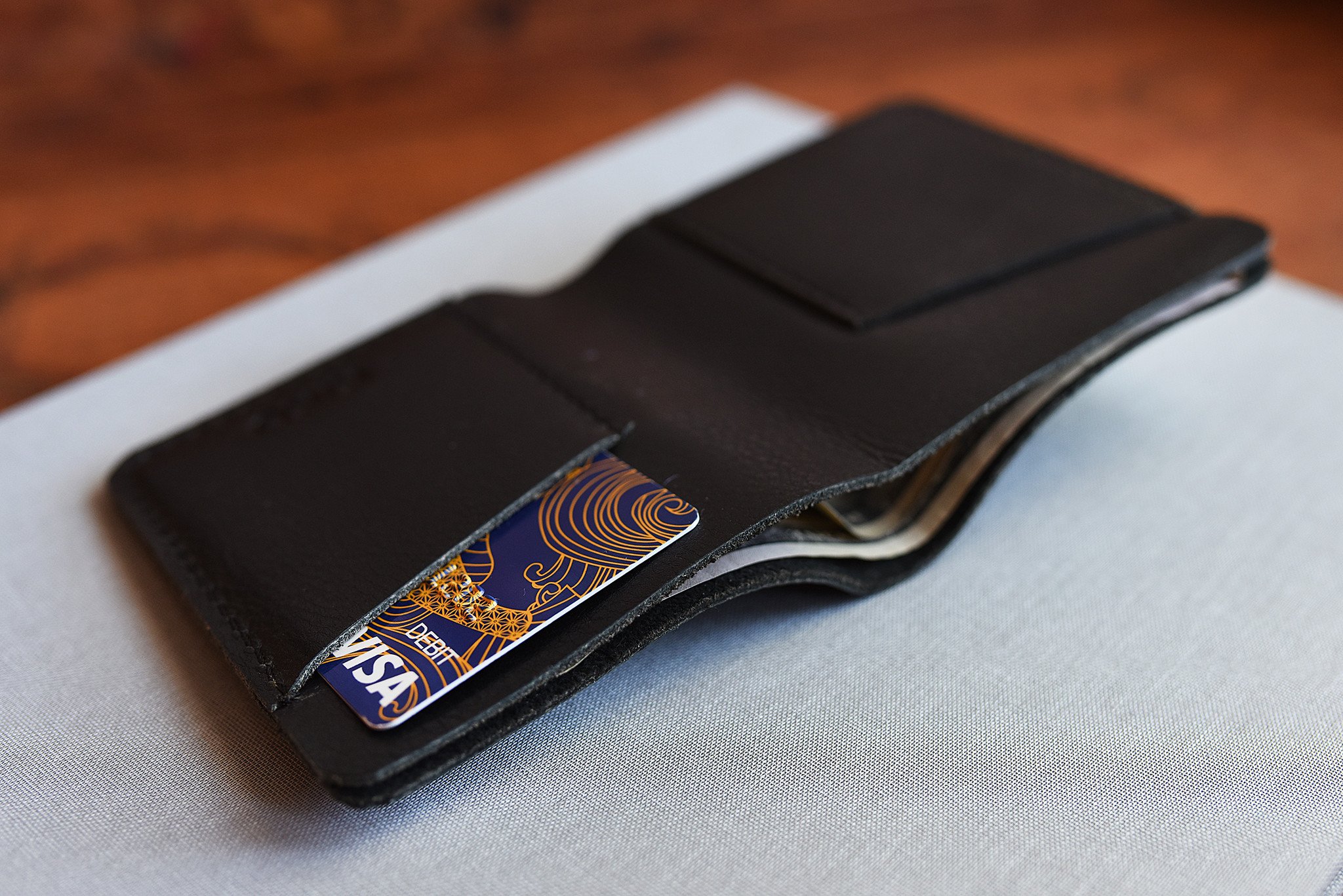 A sleek black leather Ram Wallet with two card slots and a bill compartment, showcasing its minimalistic design.