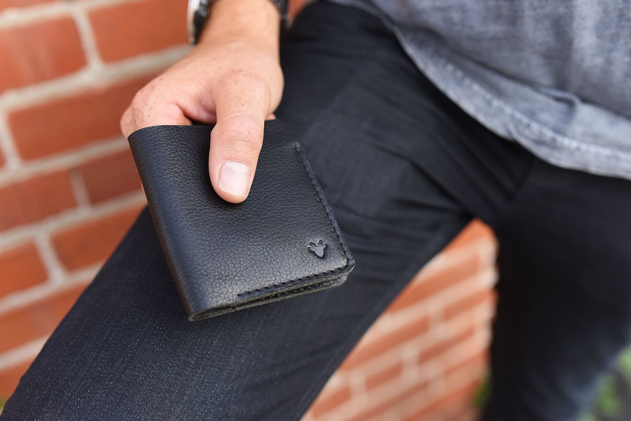 A sleek black leather Ram Wallet with two card slots and a bill compartment, showcasing its minimalistic design.