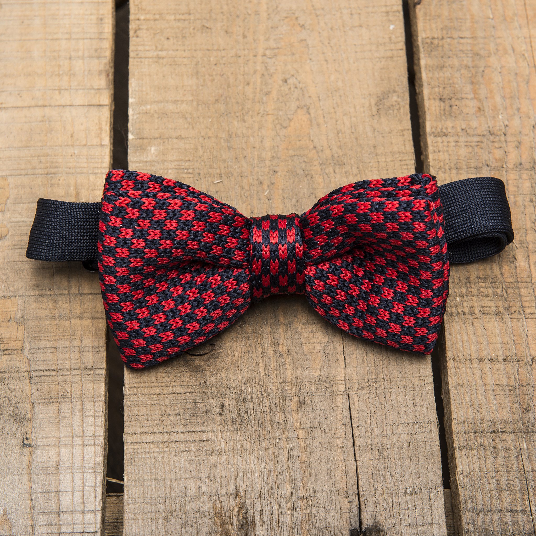 A stylish red and blue chequered bow tie, pre-tied and adjustable, made from durable polyester.