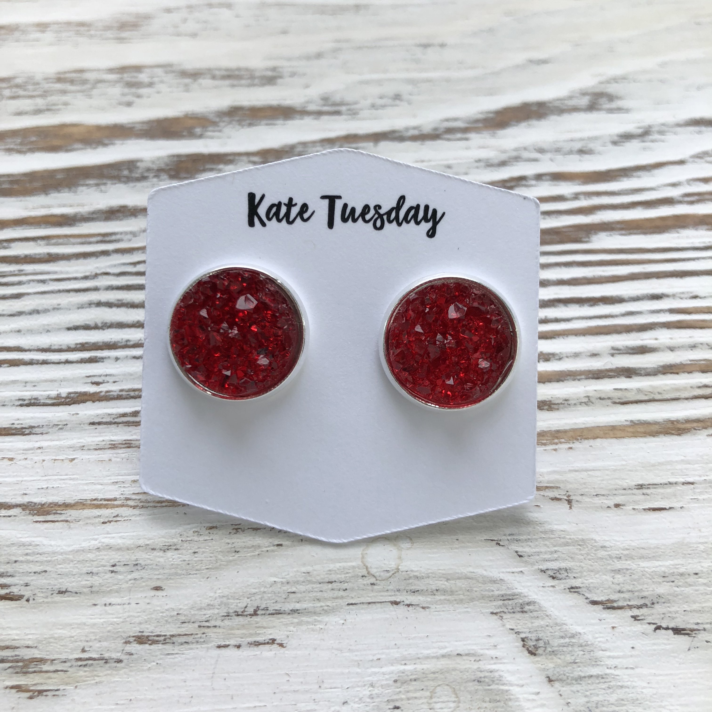 A pair of elegant red druzy earrings featuring 12mm stones on nickel and lead-free backs, available in various metal settings.