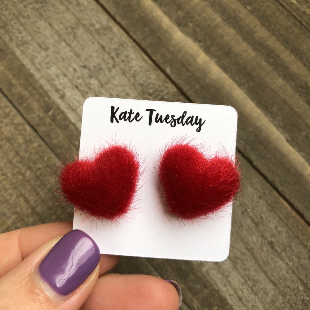 A pair of red fuzzy heart-shaped earrings, perfect for Valentine's Day, showcasing a soft texture and playful design.