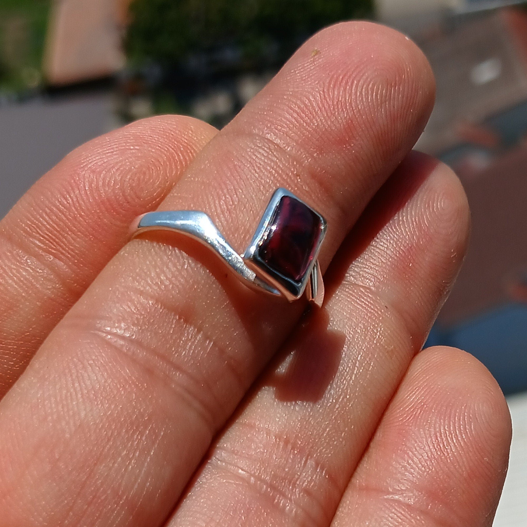 Elegant Red Garnet Ring in sterling silver with a rectangle-shaped cabochon, showcasing a polished band and minimalist design.