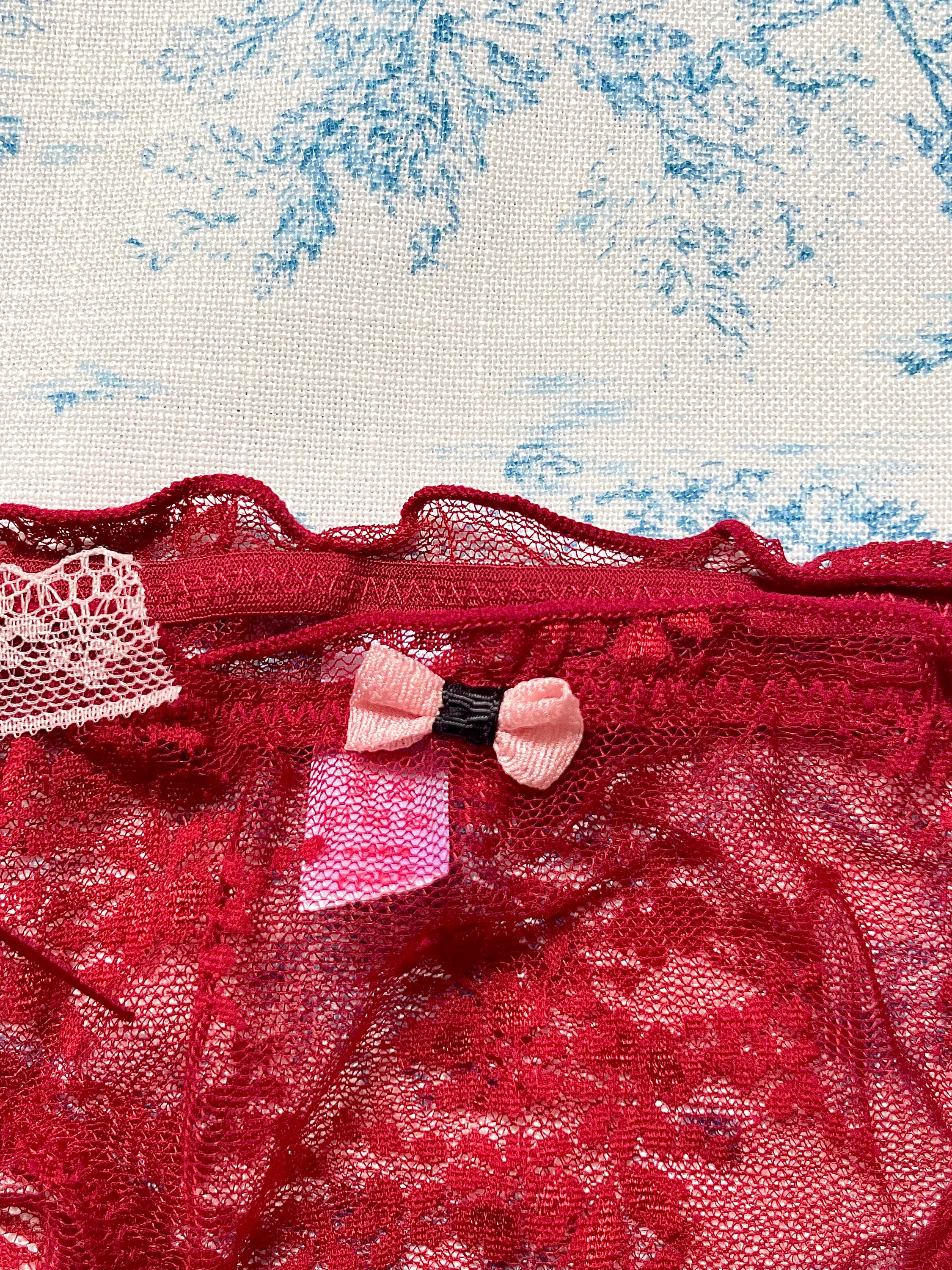 Red Lace Tie Panty featuring a delicate lace design and pink bow detail, showcasing luxurious satin and comfortable cotton lining.