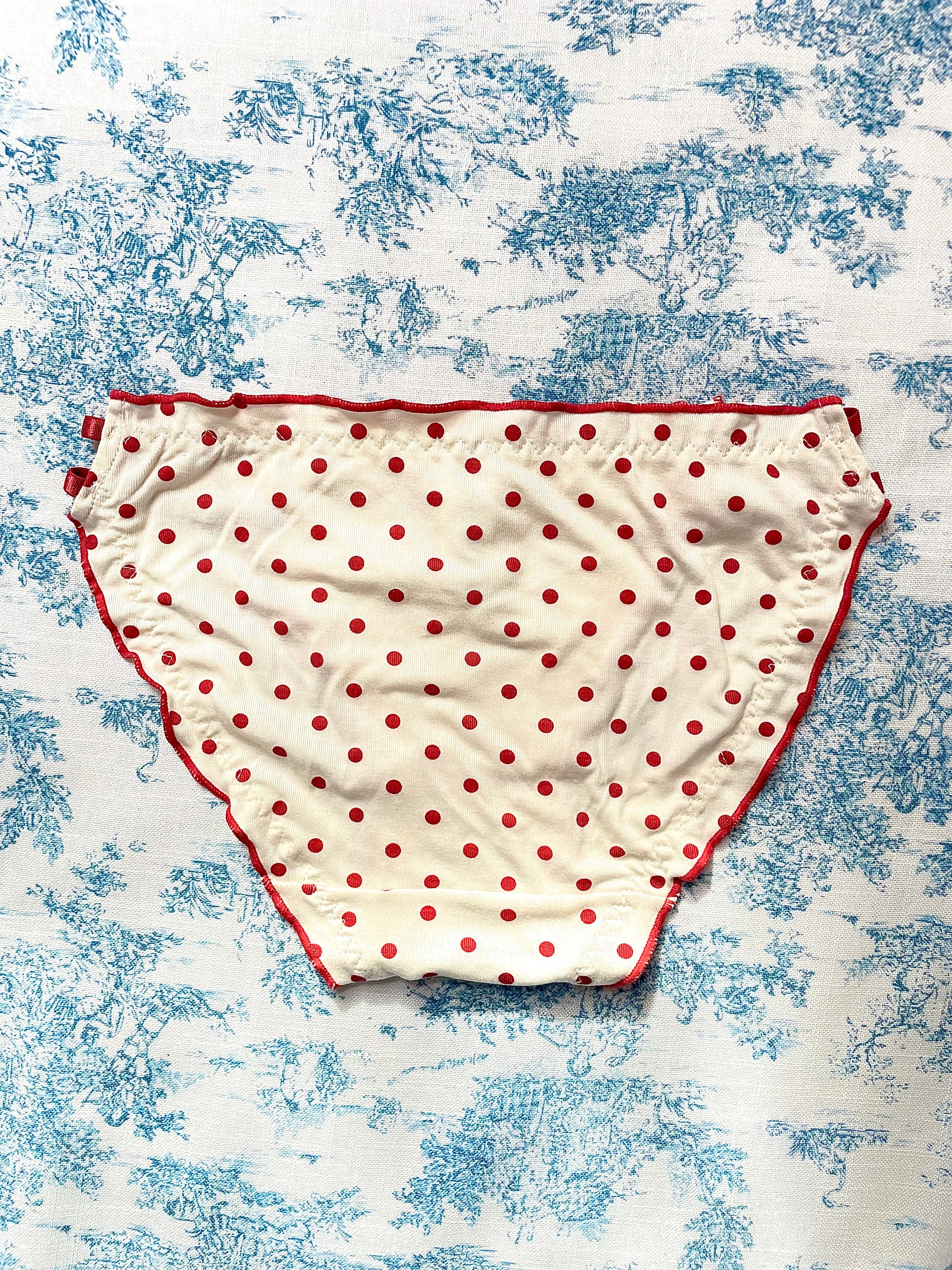 Red Polka Dot Panty with delicate lettuce trim and bow details, showcasing a playful design.