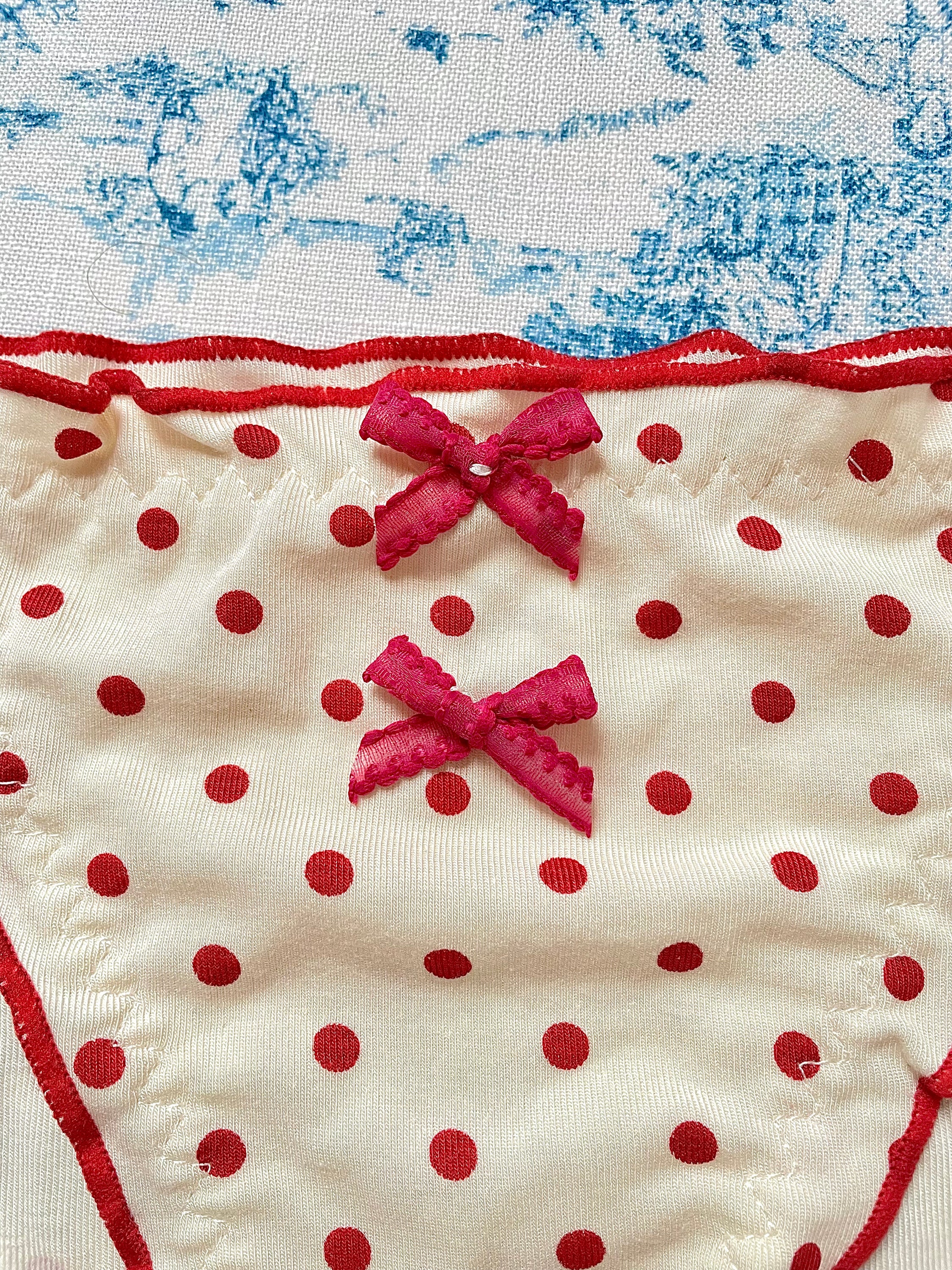 Red Polka Dot Panty with delicate lettuce trim and bow details, showcasing a playful design.