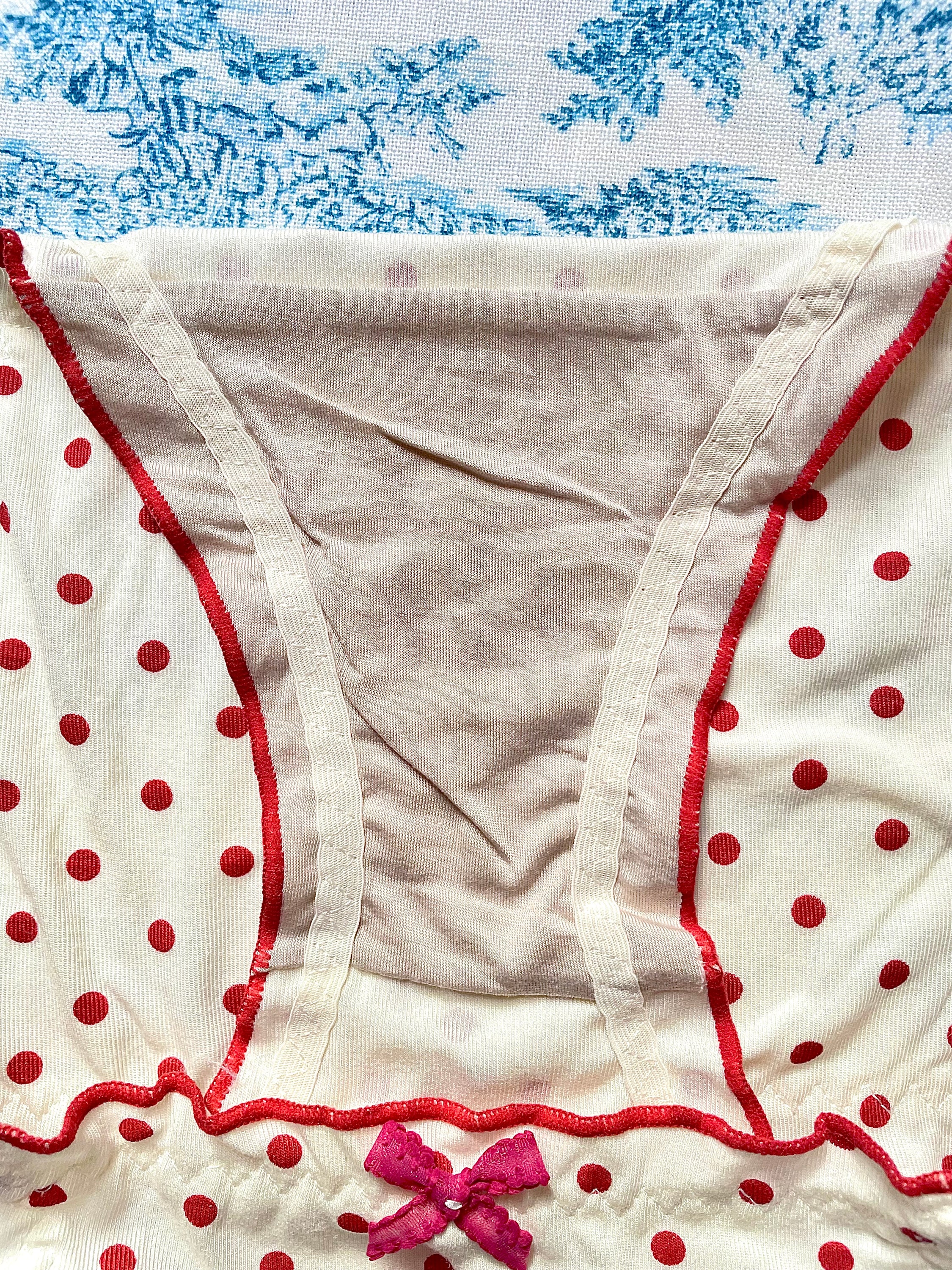 Red Polka Dot Panty with delicate lettuce trim and bow details, showcasing a playful design.