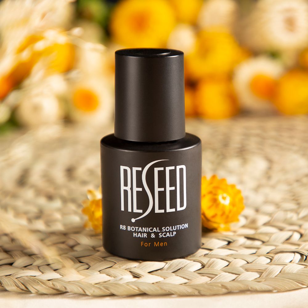 Bottle of RESEED R8 Botanical Hair Solution for Men, featuring a sleek design with a dropper for easy application.