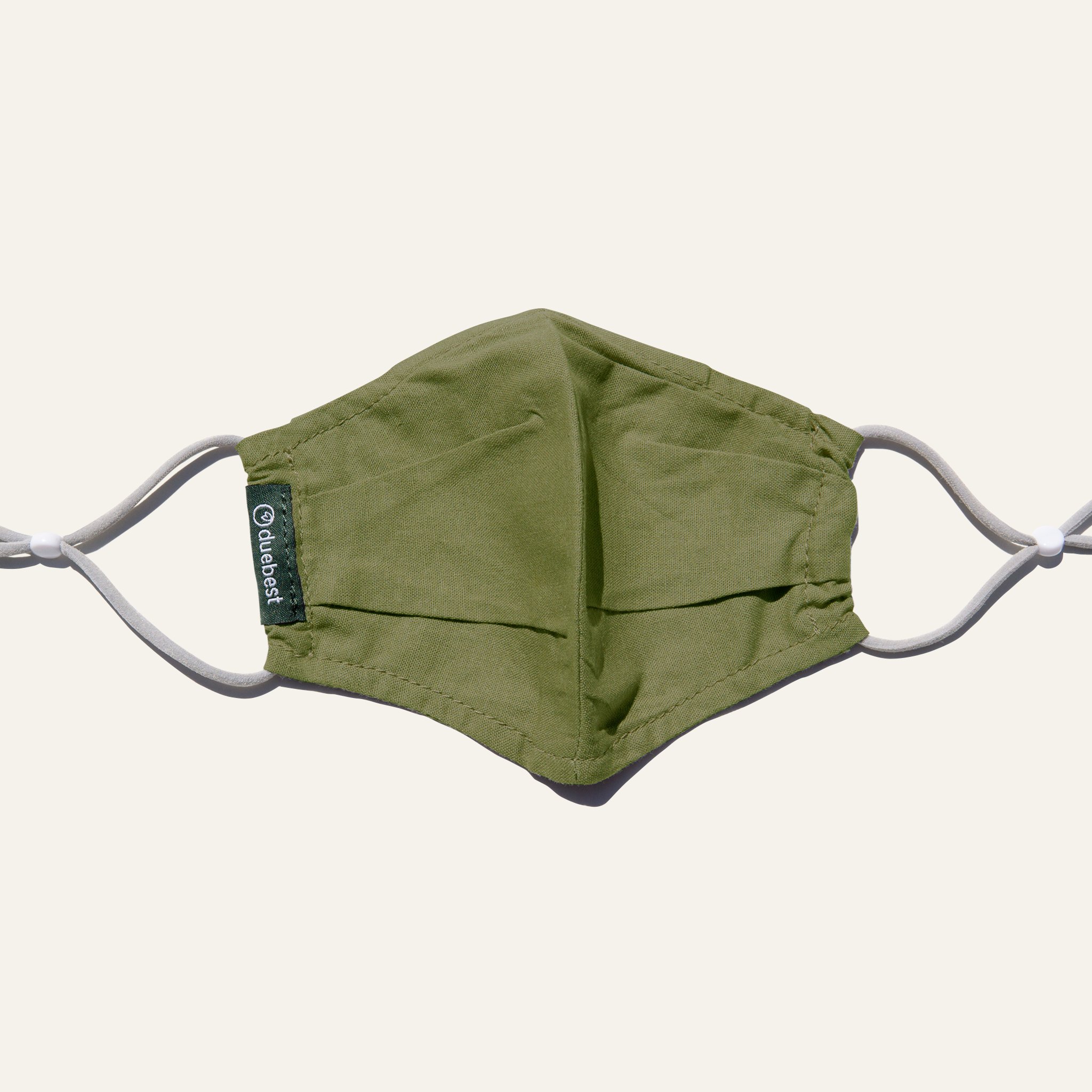 Olive green reusable fabric mask made from cotton and linen blend, featuring adjustable earloops and pleated design for comfort and coverage.