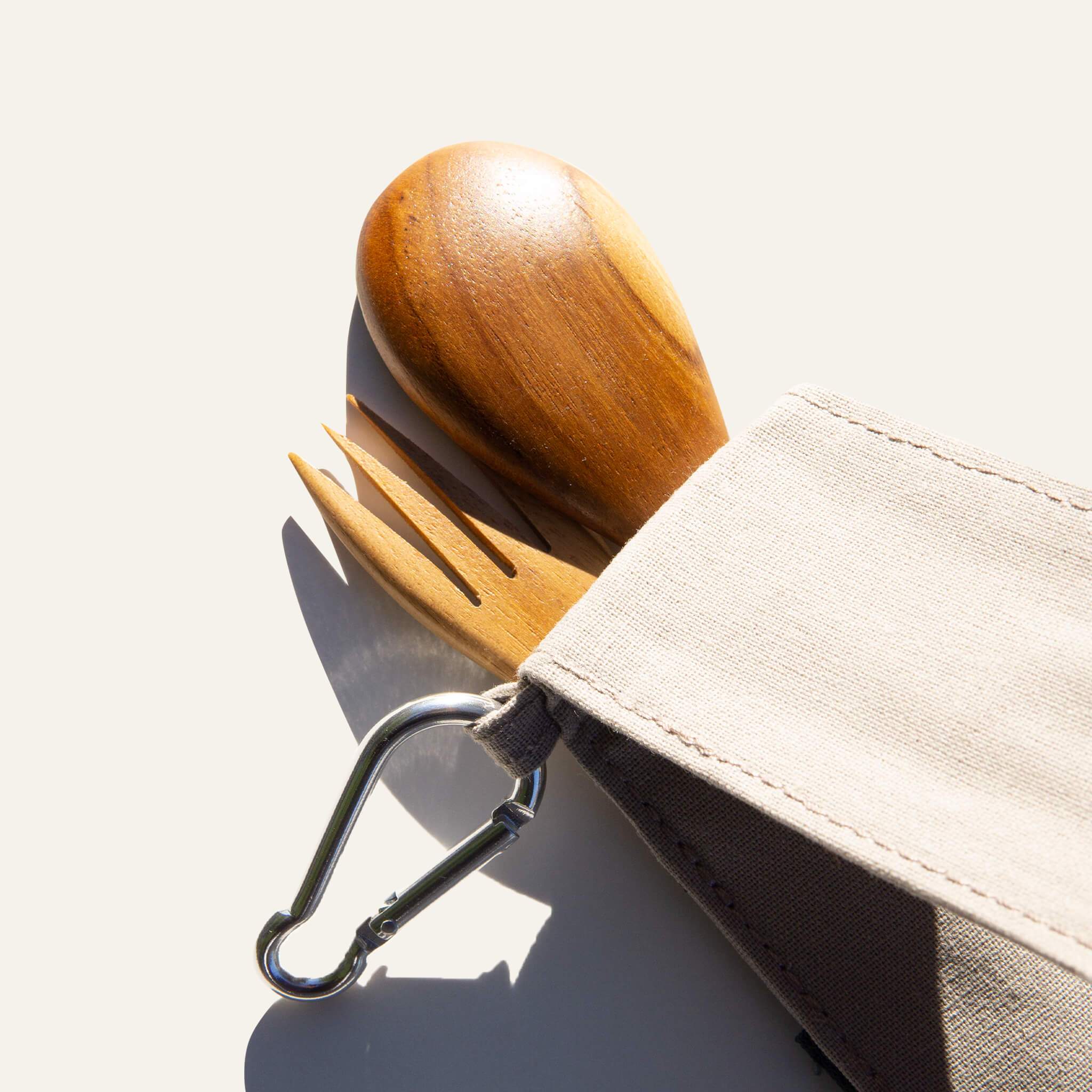 Compact Duebest™ reusable wooden cutlery set featuring hand-carved teak utensils and a fabric case with a metal carabiner.