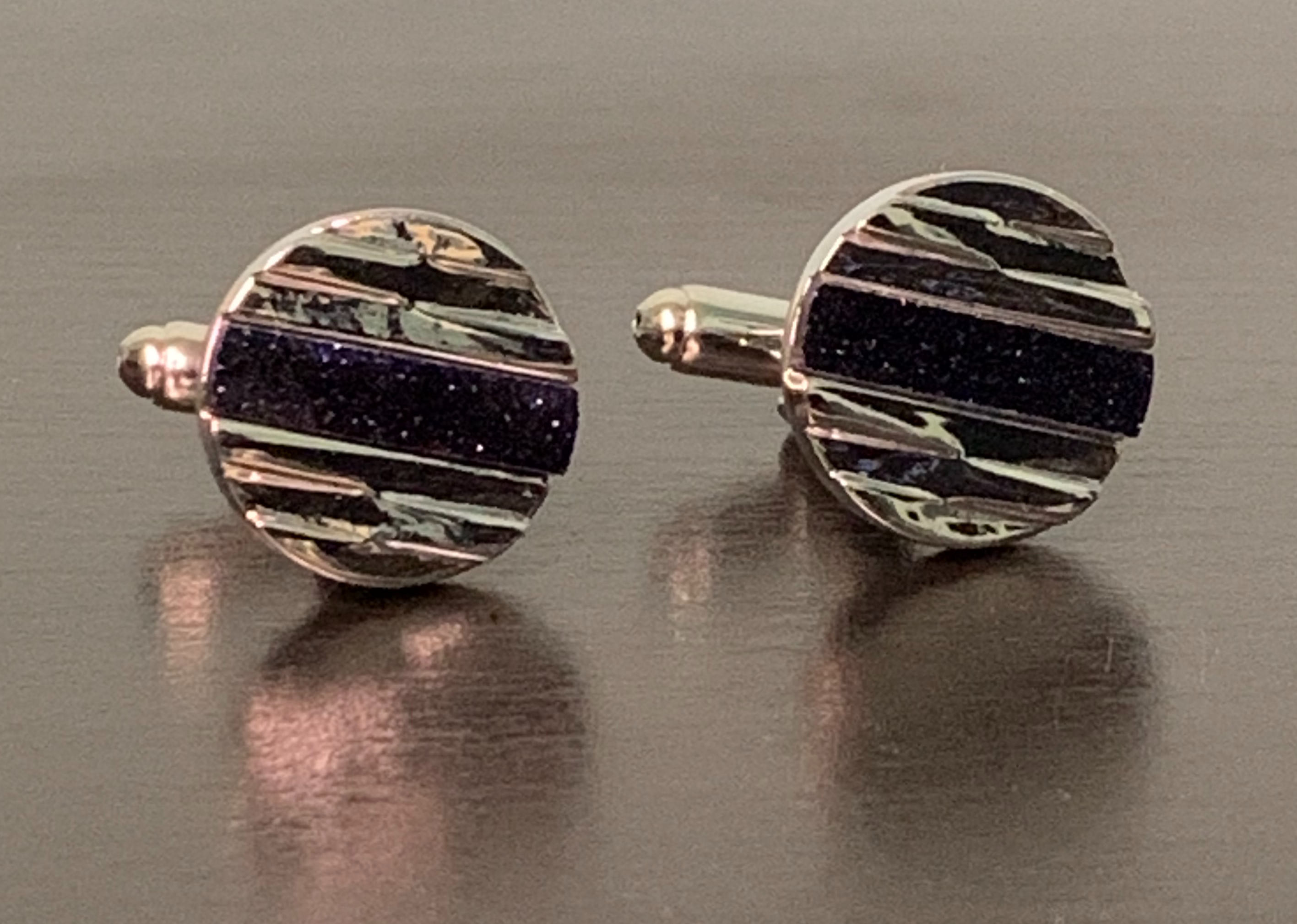 Rock Star Cufflinks featuring hewn silver design and sparkling blue center, symbolizing elegance and individuality.