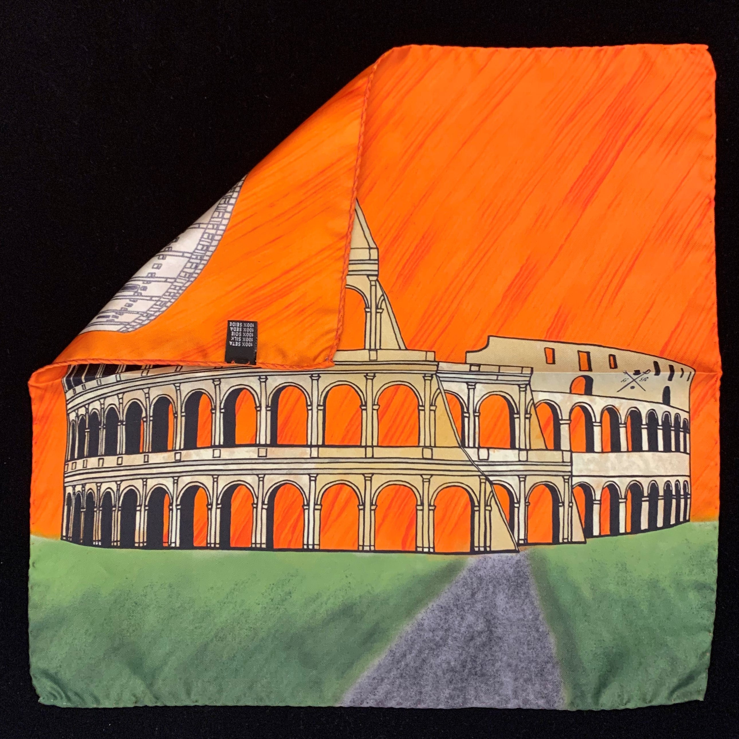 Rome Colosseum Orange Pocket Square featuring hand-sketched design in vibrant colors of orange, gold, green, and sandstone on luxurious silk.