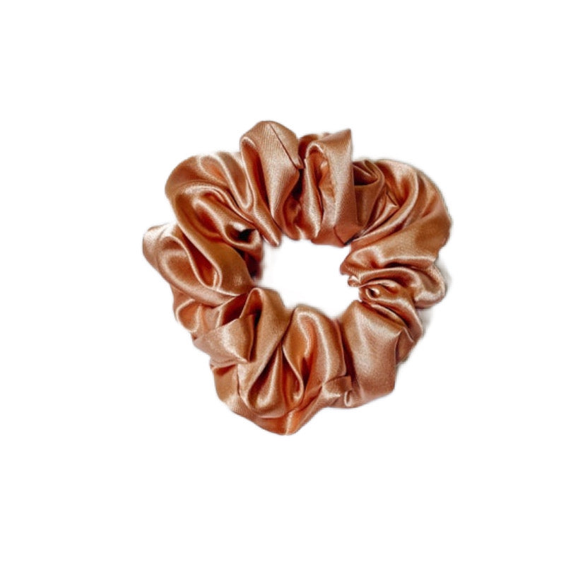 A luxurious rose gold silk satin scrunchie, handmade with soft fabric, perfect for stylish hair management.