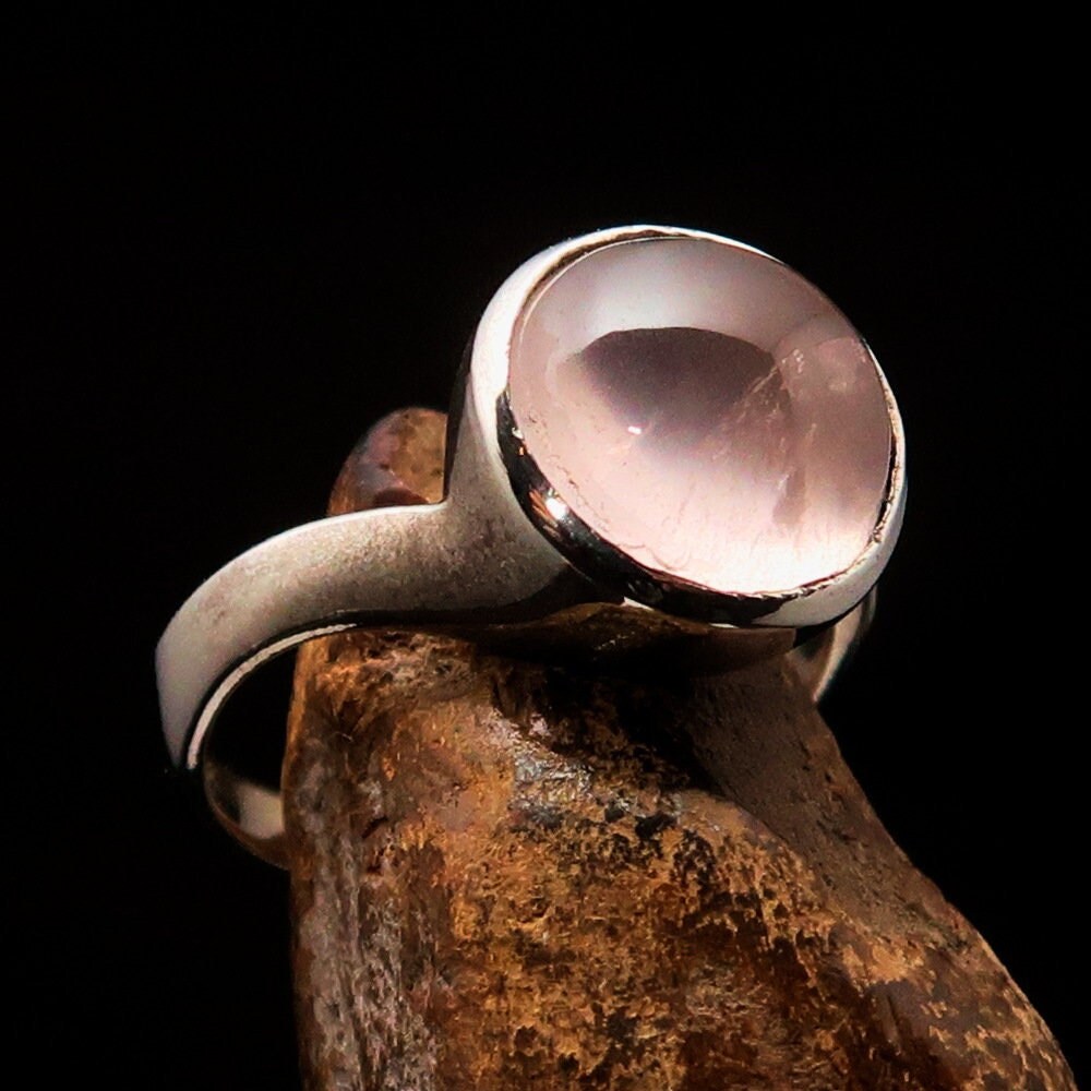 A stunning rose quartz ring set in polished sterling silver, featuring a round cabochon stone, perfect for elegant occasions.