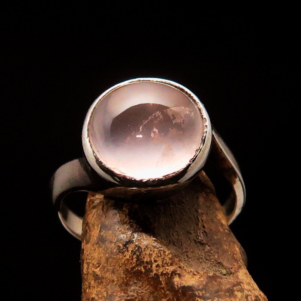 A stunning rose quartz ring set in polished sterling silver, featuring a round cabochon stone, perfect for elegant occasions.