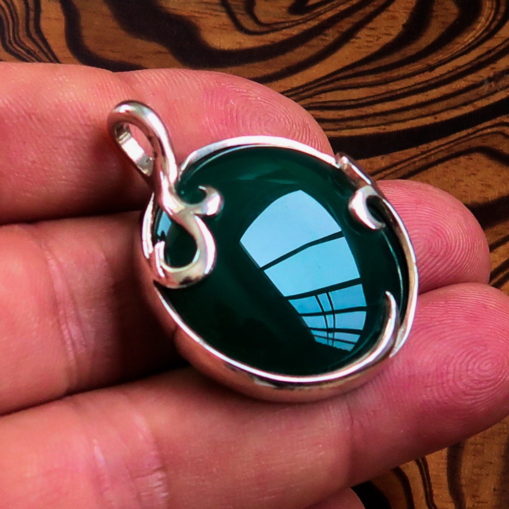 Round Agate Pendant in sterling silver featuring a green Agate cabochon, showcasing intricate design and elegant bail.