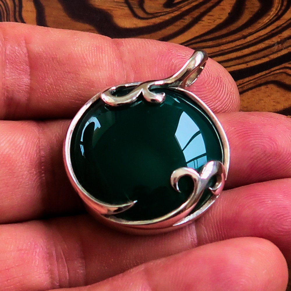 Round Agate Pendant in sterling silver featuring a green Agate cabochon, showcasing intricate design and elegant bail.