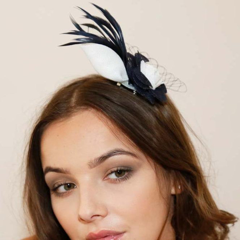 Ruby Rocks Florita Fascinator in Navy featuring a navy and ivory flower, delicate feathers, and a veil, secured with a hair clip.