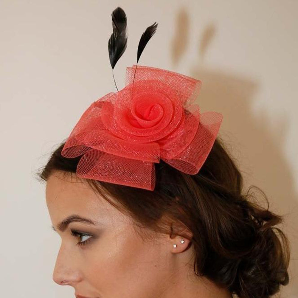 Ruby Rocks Norita Fascinator in Coral featuring a flower and feather design, secured with a hair clip.