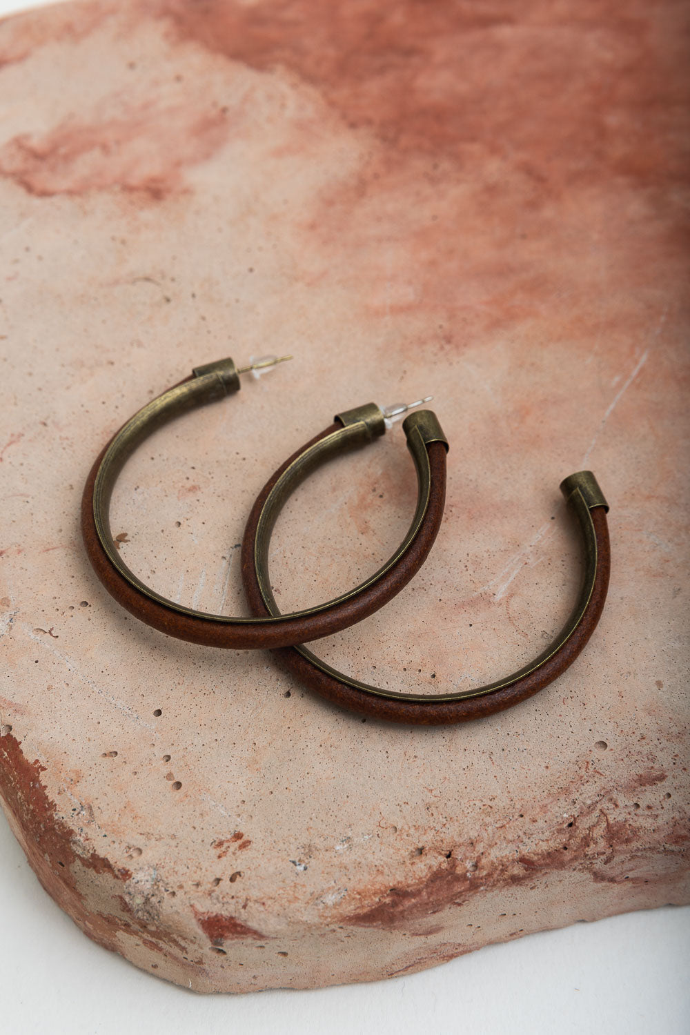 Rustic Charm Leather & Brass Hoop Earrings featuring a unique leather and brass design, perfect for trendy outfits.