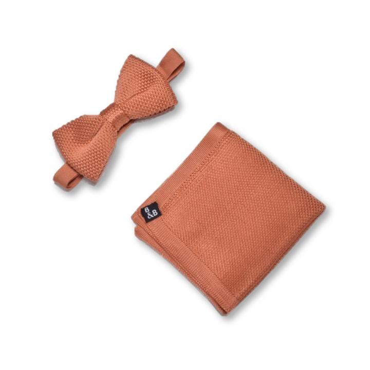 Rustic orange knitted bow tie and matching pocket square set displayed elegantly, showcasing their unique texture and vibrant color.