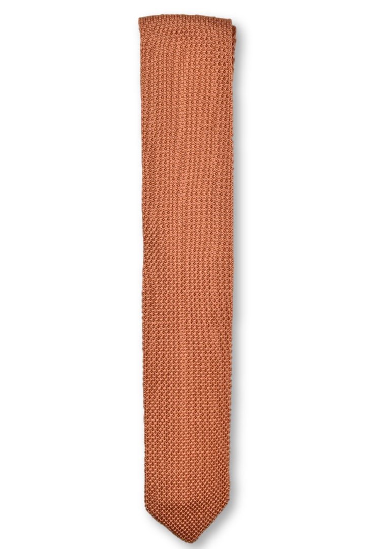 A rustic orange knitted tie with a pointed end, showcasing its unique texture and vibrant color.