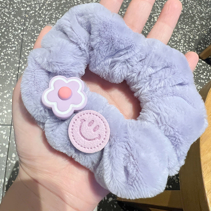 A person holding a set of five vibrant pink and purple scrunchies, showcasing their stylish design and quality material.