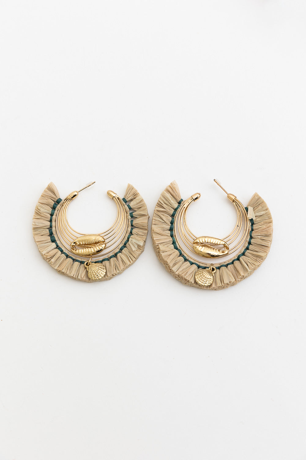 A pair of Seashell Raffia Earrings featuring delicate hoops adorned with shimmering seashells and golden raffia, showcasing coastal elegance.