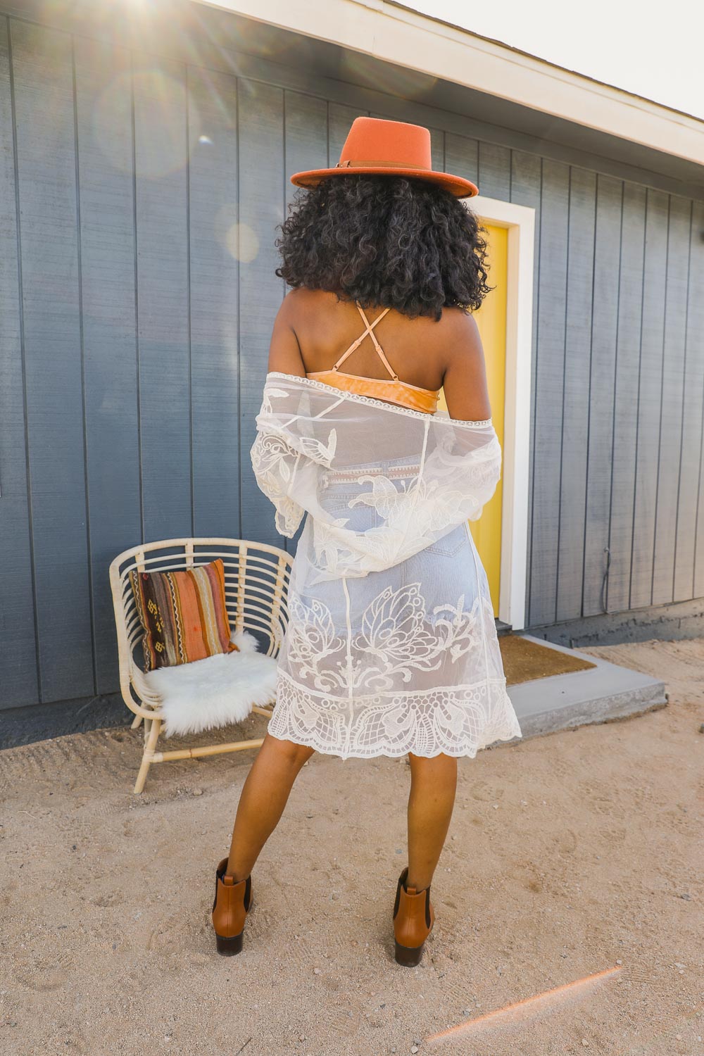 A stylish see-through embroidered lace kimono draped elegantly, showcasing intricate lace detailing and a relaxed fit, perfect for festivals.