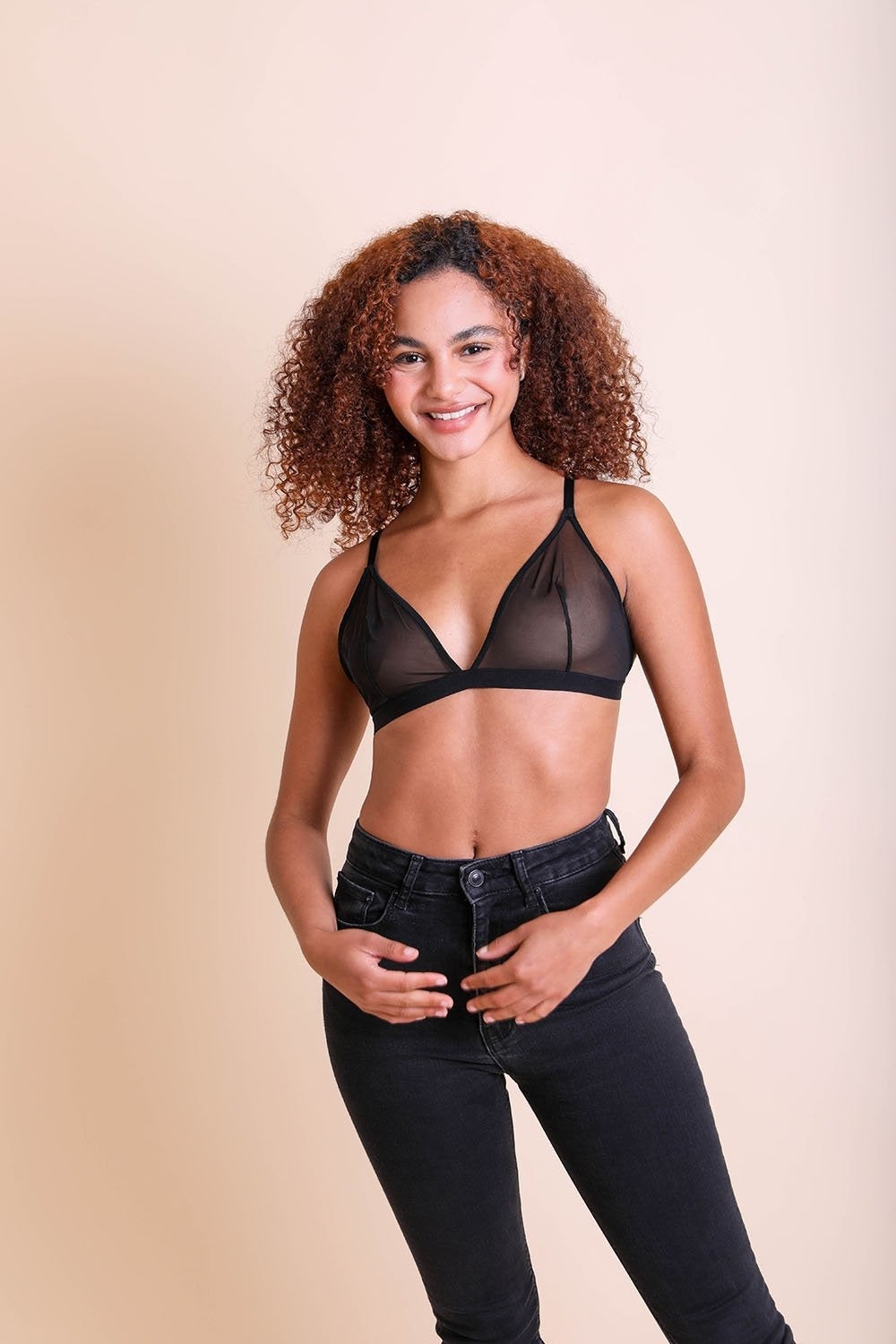 A stylish sheer mesh bralette featuring a triangle design and adjustable straps, showcasing its soft and feathery texture.