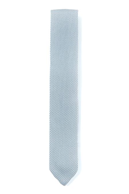 A stylish silver knitted tie with a pointed end, showcasing its unique texture and modern design.