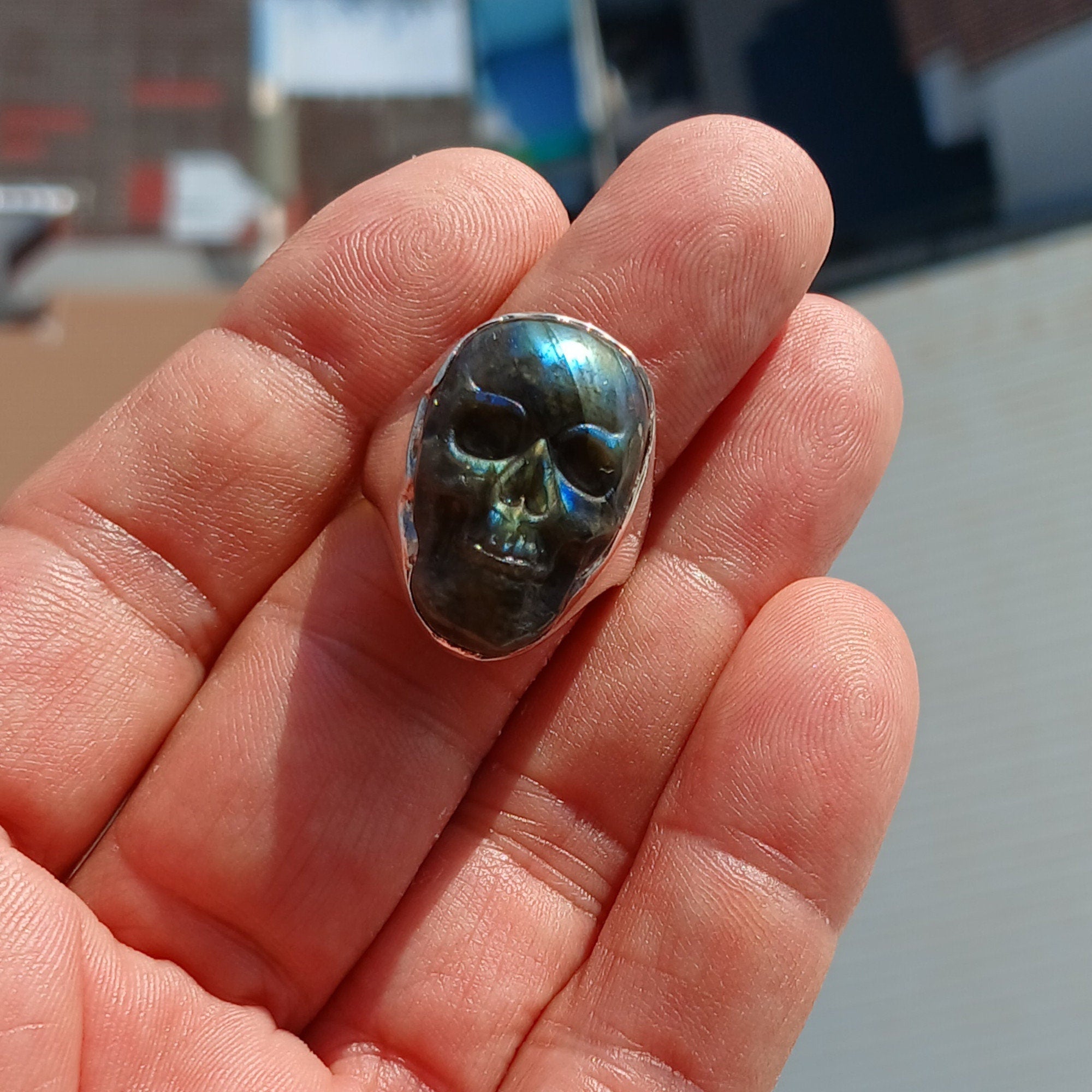 Handmade sterling silver skull ring with Labradorite stone carving, showcasing intricate details and a polished finish.