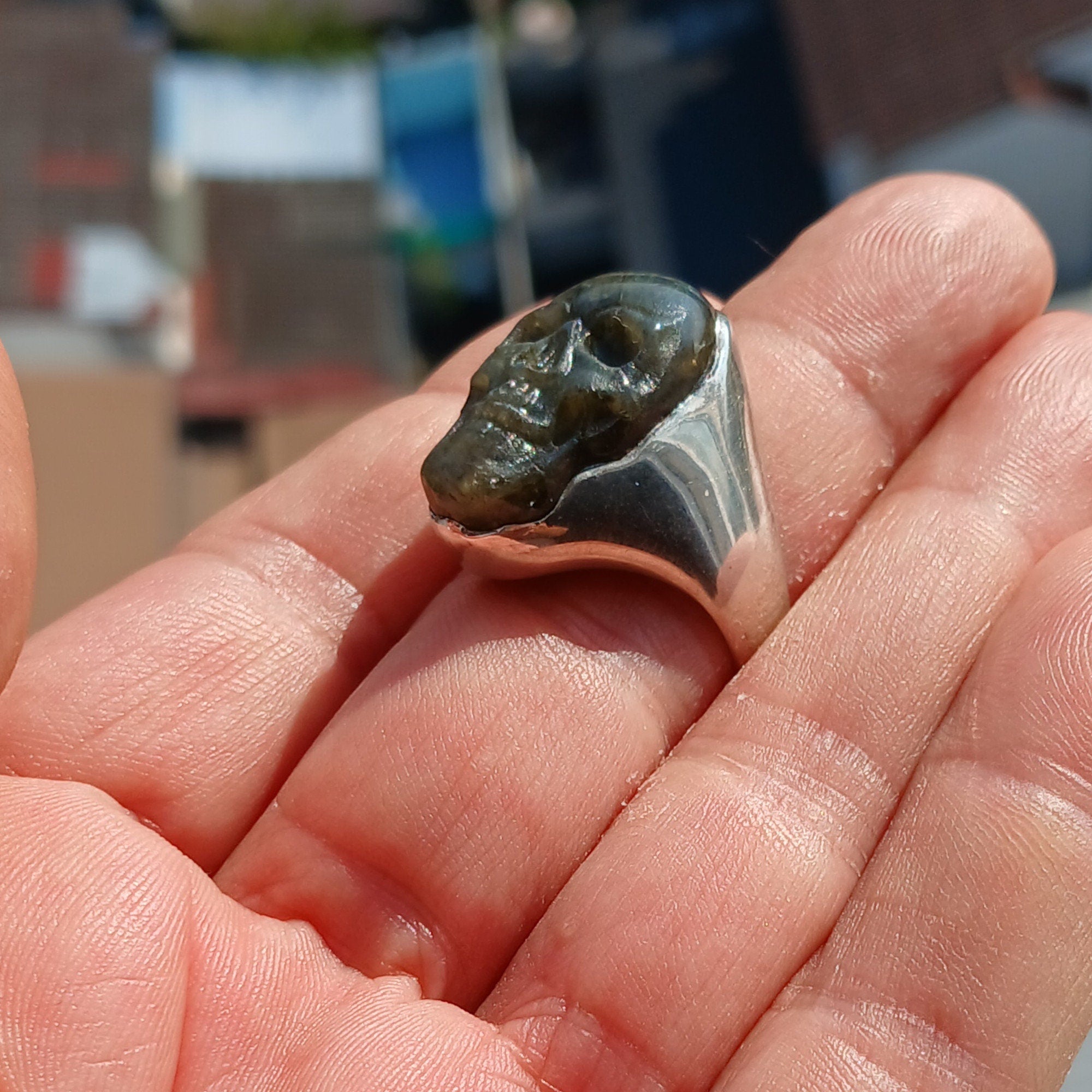 Handmade sterling silver skull ring with Labradorite stone carving, showcasing intricate details and a polished finish.