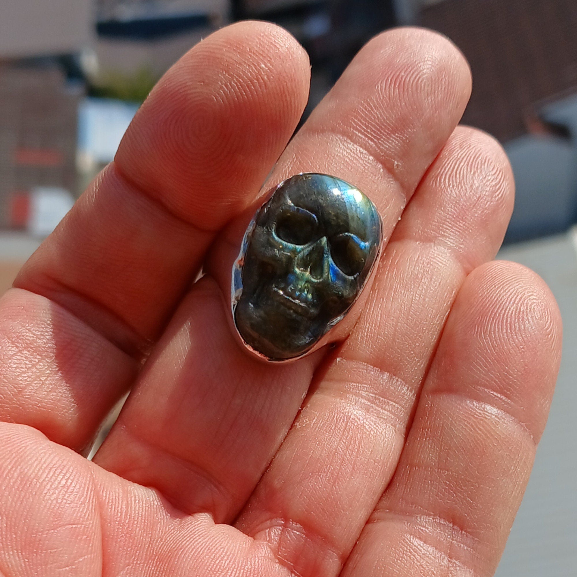 Handmade sterling silver skull ring with Labradorite stone carving, showcasing intricate details and a polished finish.