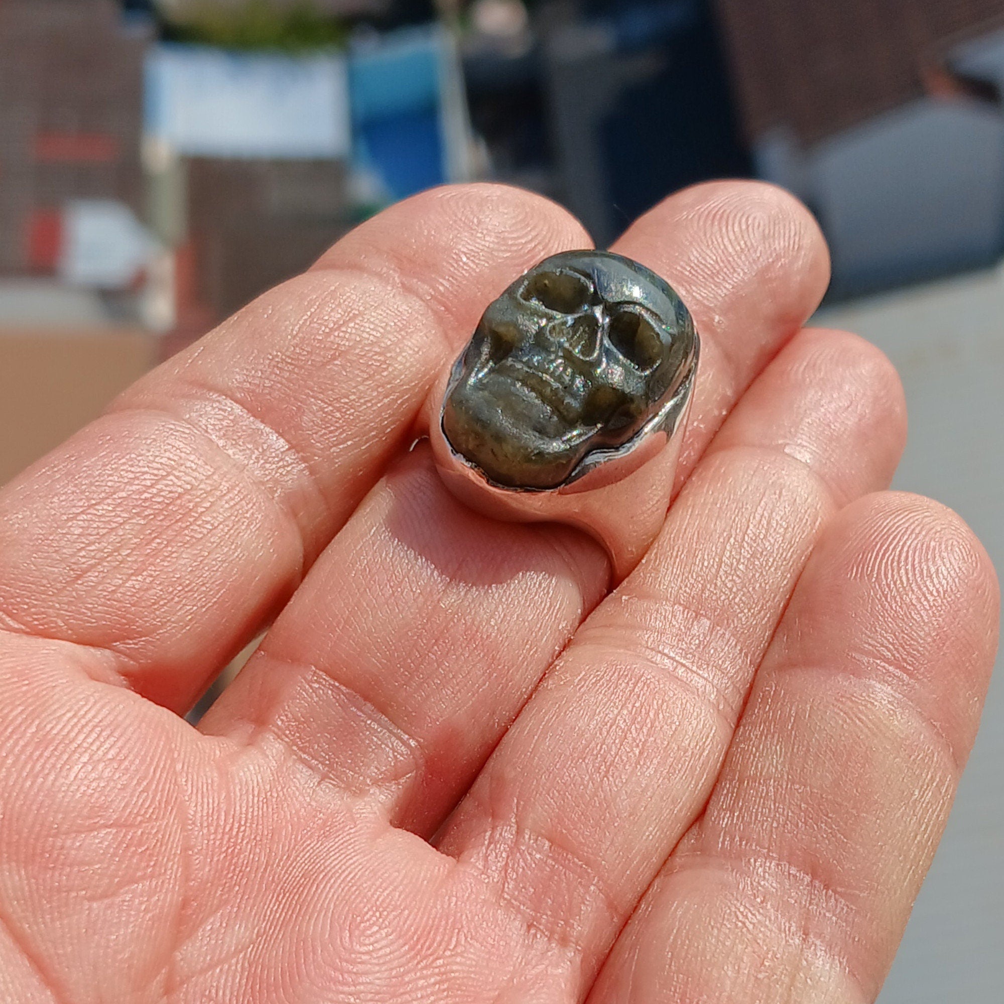 Handmade sterling silver skull ring with Labradorite stone carving, showcasing intricate details and a polished finish.