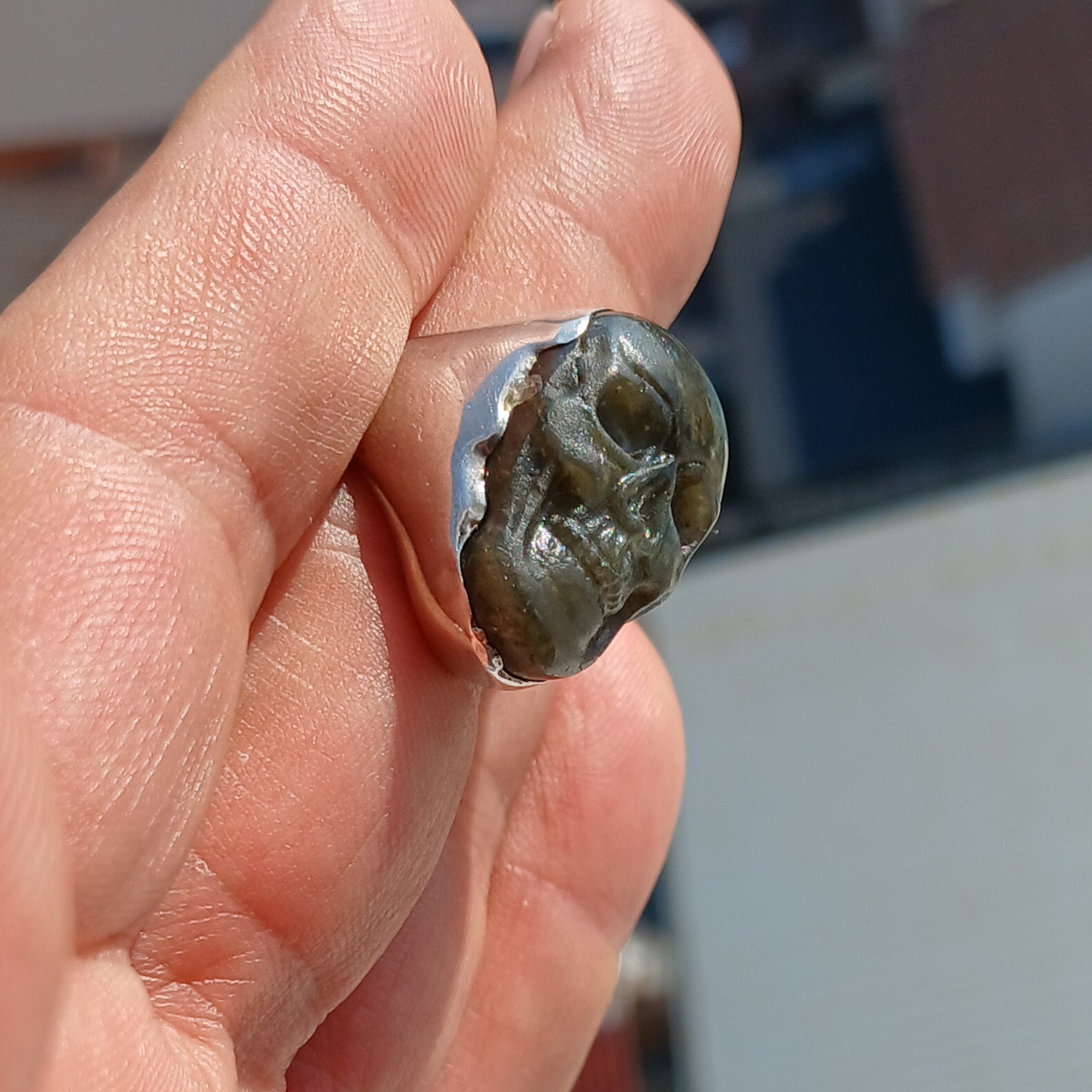 Handmade sterling silver skull ring with Labradorite stone carving, showcasing intricate details and a polished finish.