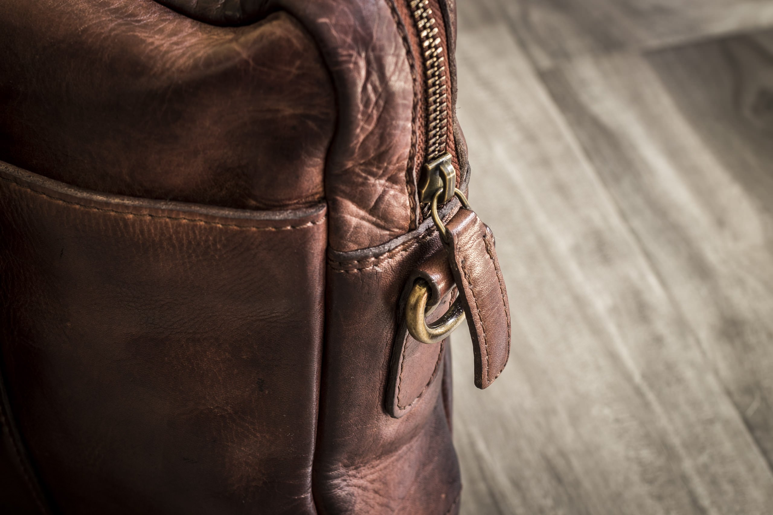 A stylish Sleek Brief made of genuine washed leather, featuring an adjustable shoulder strap and multiple pockets for organization.