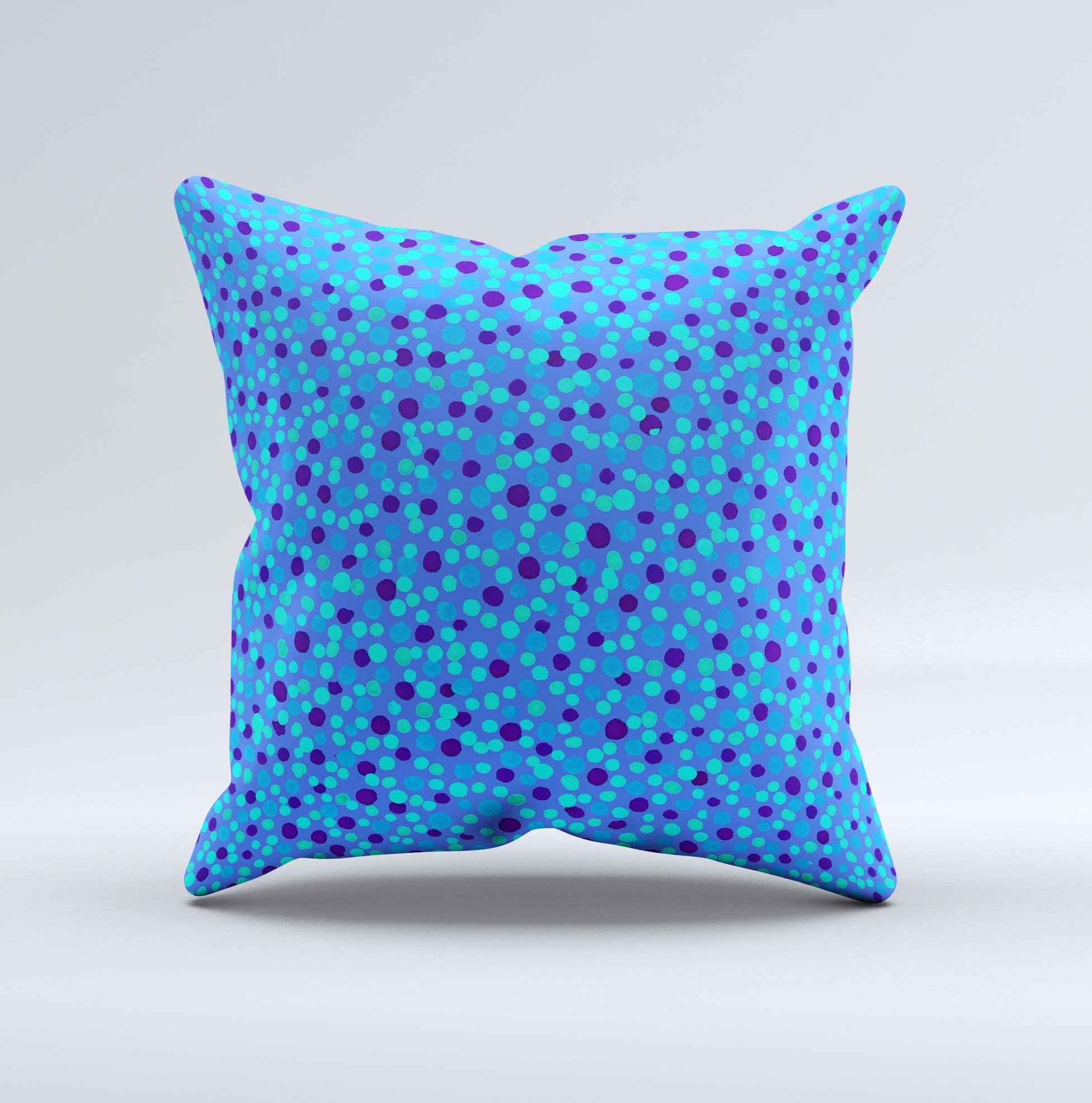 A decorative throw pillow featuring small scattered polka dots in blue ink on a soft fabric, handcrafted in Virginia.