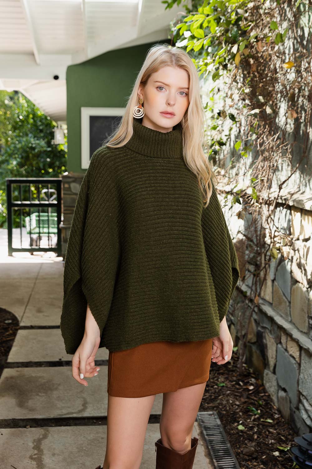 SnugStyle Turtleneck Ribbed Knit Poncho with Armholes in a cozy setting, showcasing its stylish ribbed texture and turtleneck design.