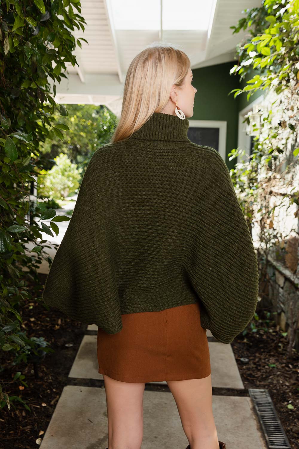 SnugStyle Turtleneck Ribbed Knit Poncho with Armholes in a cozy setting, showcasing its stylish ribbed texture and turtleneck design.