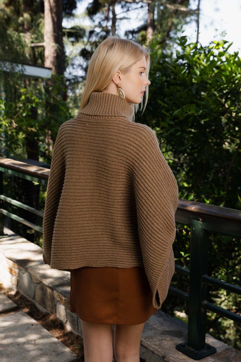 SnugStyle Turtleneck Ribbed Knit Poncho with Armholes in a cozy setting, showcasing its stylish ribbed texture and turtleneck design.