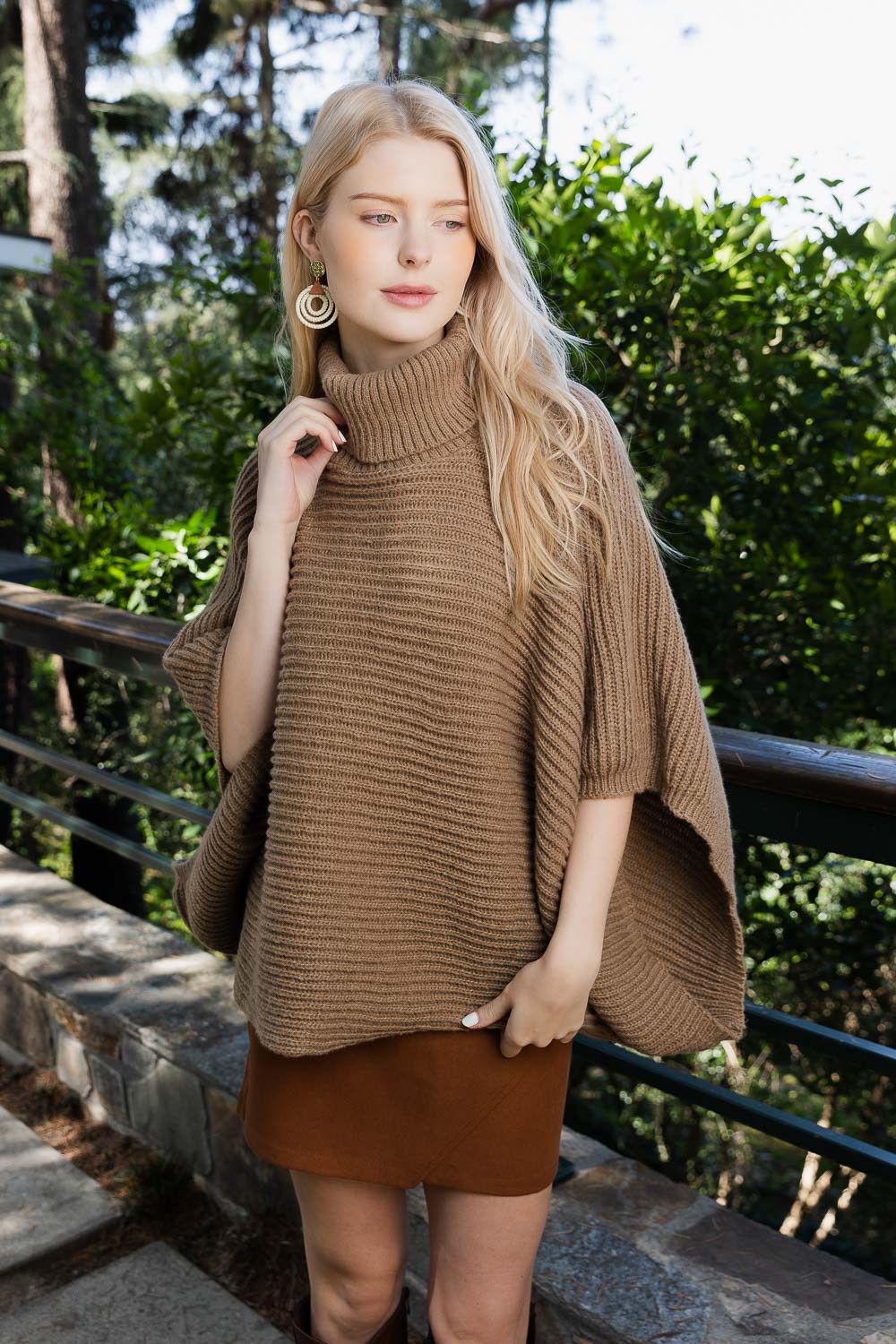 SnugStyle Turtleneck Ribbed Knit Poncho with Armholes in a cozy setting, showcasing its stylish ribbed texture and turtleneck design.